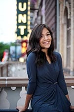 Author Nicole Rosales sits outside with street in background