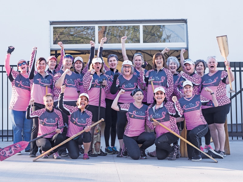 women rowers in a group with paddles