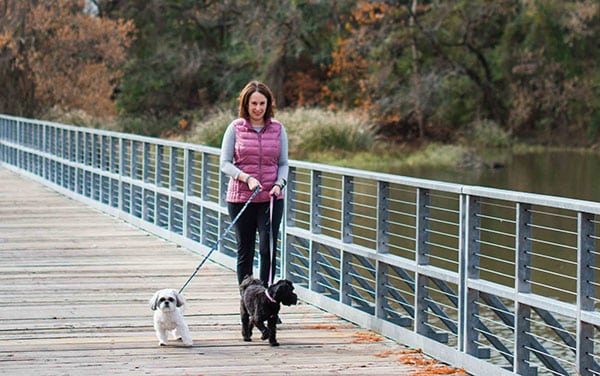 Woman bonds with her two dogs by exercising.